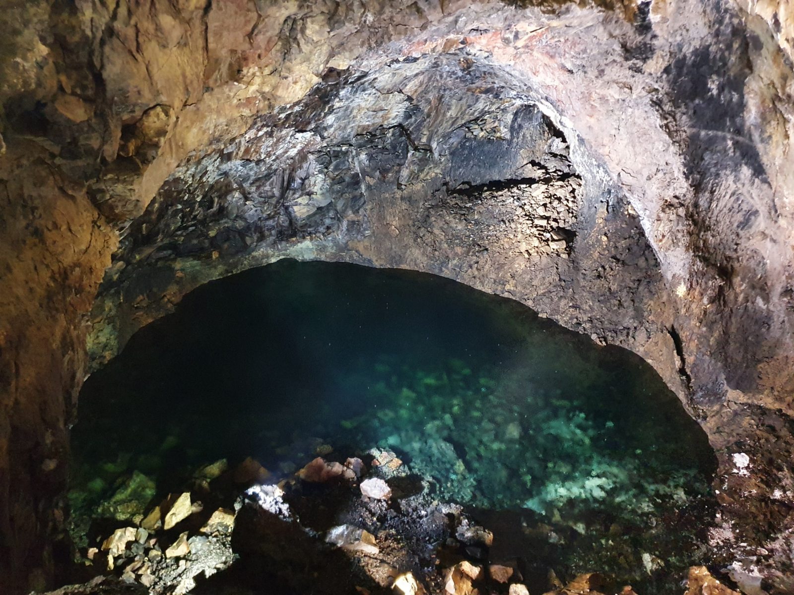 The clear lagoon beneath the rock vault at Algar do Carvão