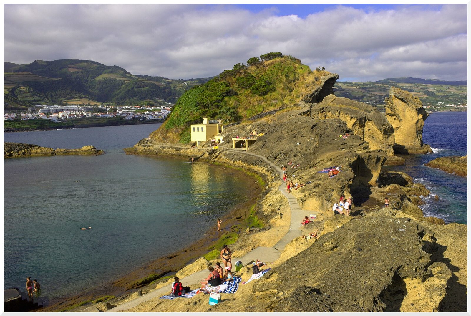People on the rocks beside the crater lagoon path